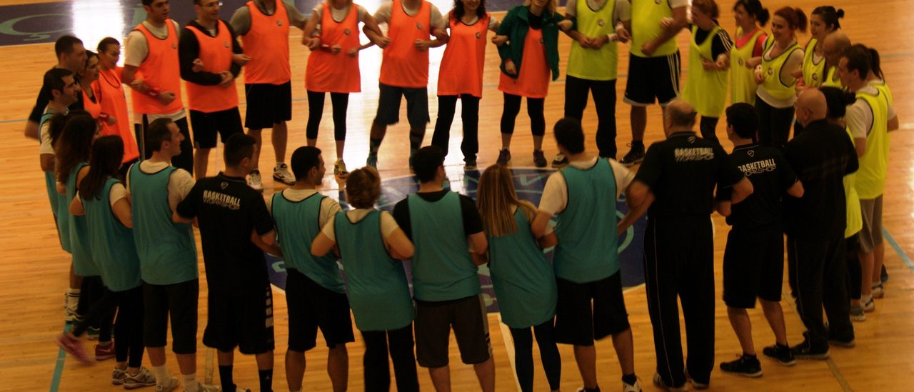 Spor salonunda geniş bir çember kurmuş katılımcılar — arkadan görünüm